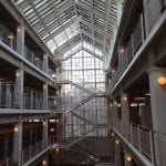 Three floors of a library with a glass roof above