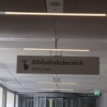 A hanging sign indicating that users should be quiet in the library area