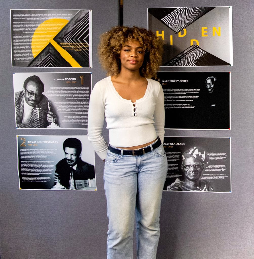 Photo of Leslie Mfonow Tochukwu (3rd Year Student – Bachelor of Architecture 2023) in front of the display in the university library.